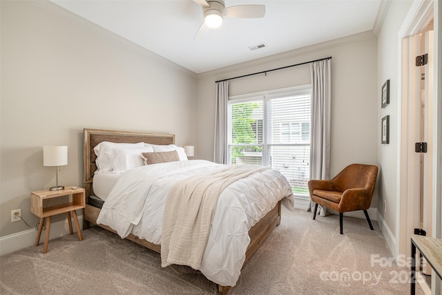 bedroom featuring light colored carpet, ornamental molding, baseboards, and a ceiling fan