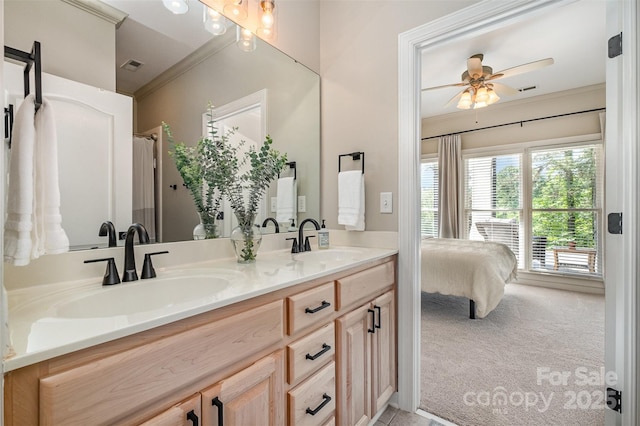 ensuite bathroom with a sink, crown molding, and double vanity