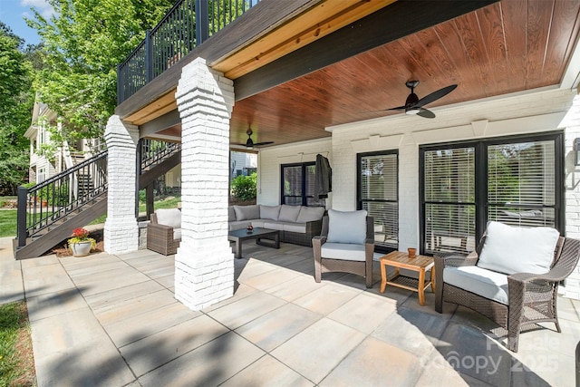 view of patio / terrace with an outdoor living space, ceiling fan, a balcony, and stairway