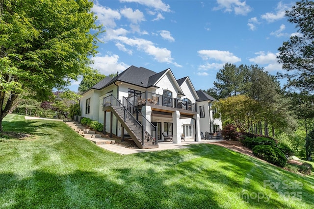 rear view of house featuring a lawn, a patio area, a wooden deck, and stairway