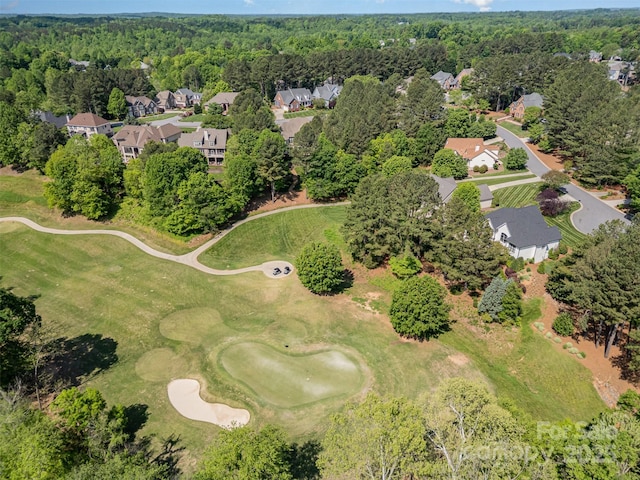 drone / aerial view with a view of trees, golf course view, and a residential view