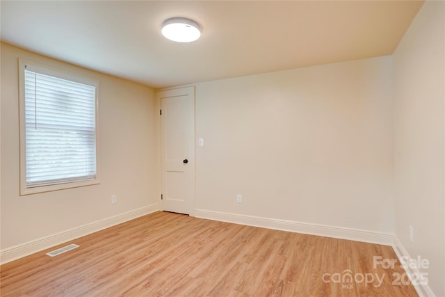 unfurnished room featuring light wood-type flooring, baseboards, and visible vents
