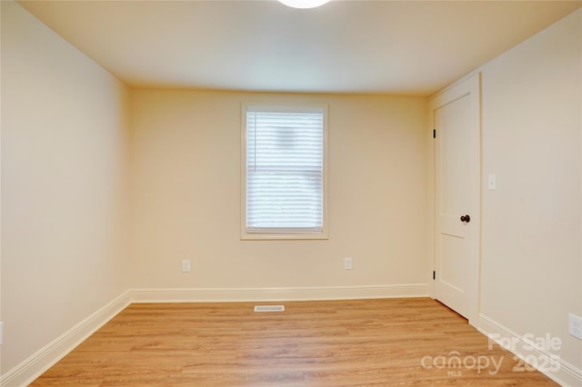 empty room with baseboards, visible vents, and light wood-style floors