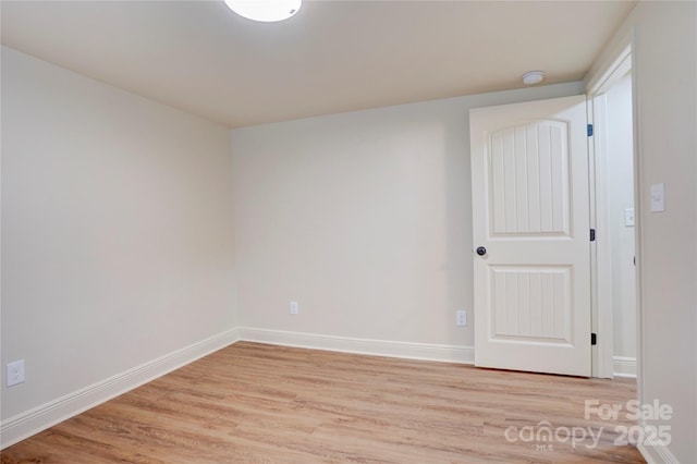 empty room with baseboards and light wood finished floors