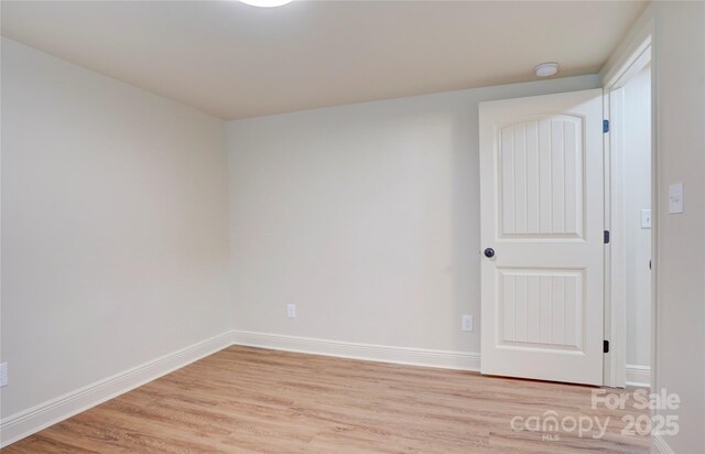 empty room featuring baseboards and light wood-style flooring