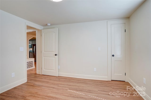 unfurnished room featuring light wood-type flooring and baseboards