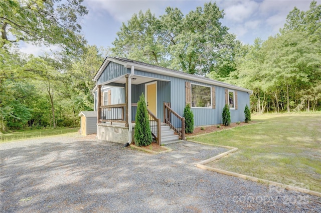 view of front of property with a storage shed, an outbuilding, and a front yard