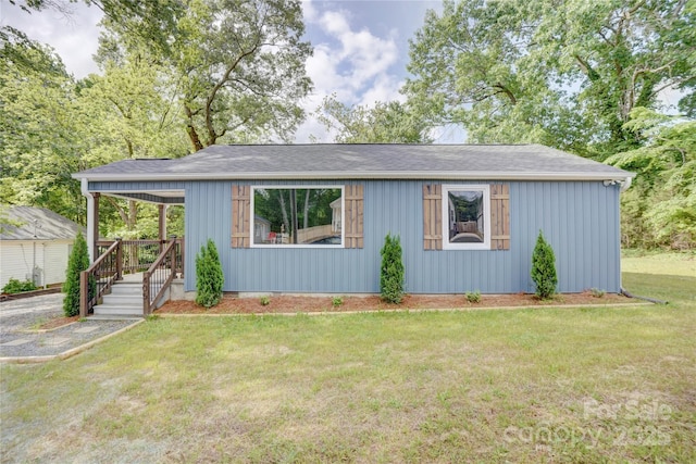 view of front of house with a shingled roof and a front yard