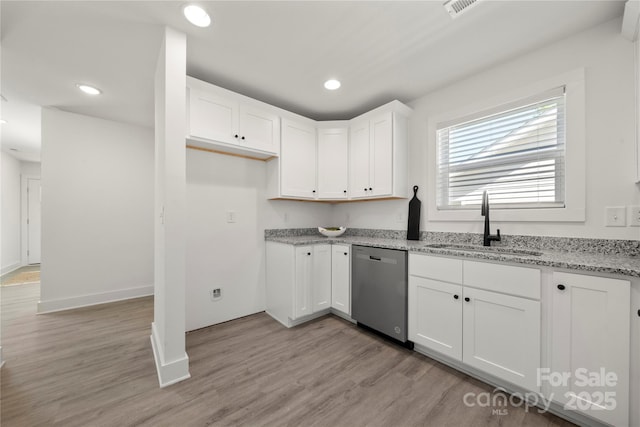 3205 Morning Dr, Charlotte, NC 28208 - kitchen featuring light stone countertops, a sink, dishwasher, light wood-style flooring, and white cabinetry