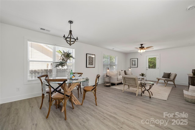 3205 Morning Dr, Charlotte, NC 28208 - dining area with visible vents, light wood-style floors, ceiling fan with notable chandelier, and baseboards