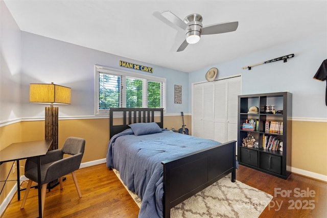 bedroom with baseboards, ceiling fan, wood finished floors, and a closet