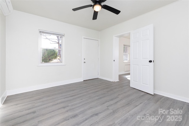 spare room with baseboards, ceiling fan, and wood finished floors