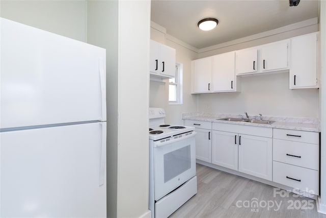 kitchen featuring white appliances, light wood-type flooring, light countertops, white cabinets, and a sink