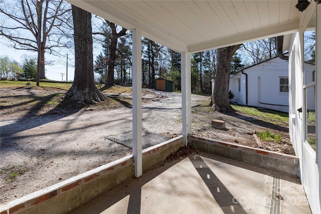 view of patio / terrace with a storage shed and an outbuilding