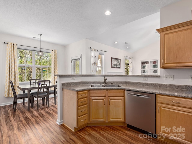 kitchen with stainless steel dishwasher, a sink, dark countertops, dark wood-style flooring, and recessed lighting