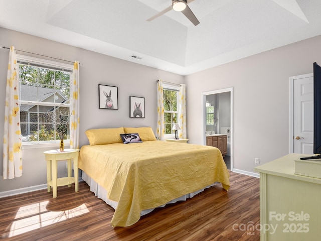 bedroom featuring baseboards, a raised ceiling, and dark wood-type flooring