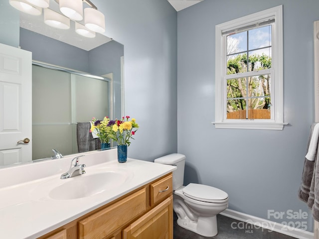 full bathroom with baseboards, a stall shower, toilet, and vanity