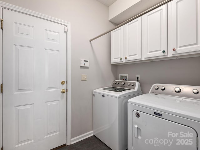 laundry area with baseboards, washer and dryer, and cabinet space