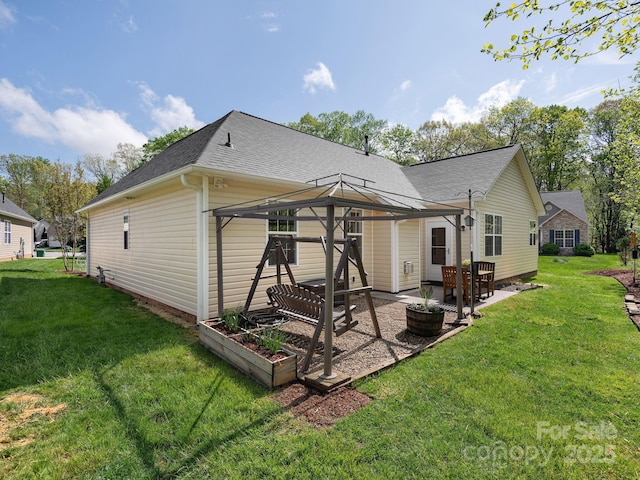 rear view of property with a lawn, a gazebo, a shingled roof, and a patio area