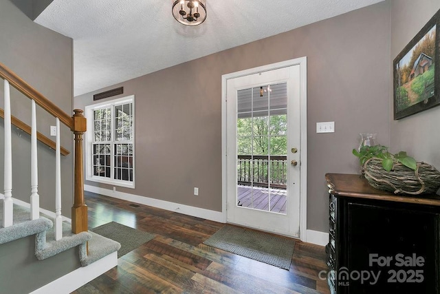 interior space with wood-type flooring, baseboards, stairway, and a healthy amount of sunlight