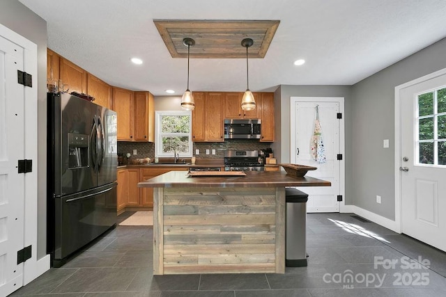 kitchen featuring pendant lighting, decorative backsplash, a sink, appliances with stainless steel finishes, and recessed lighting