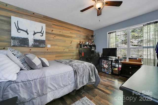 bedroom with wood finished floors, wooden walls, and a ceiling fan