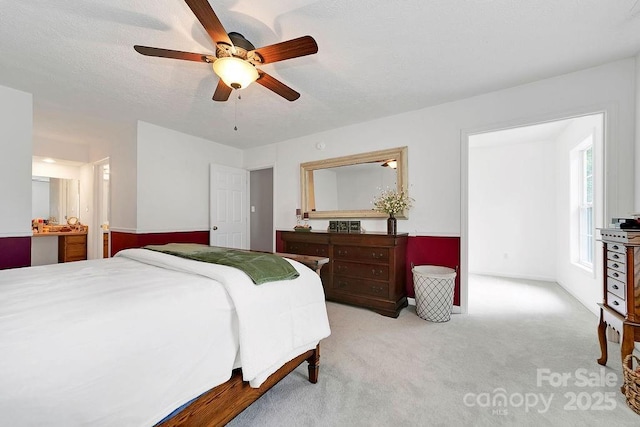 carpeted bedroom featuring ceiling fan and ensuite bath