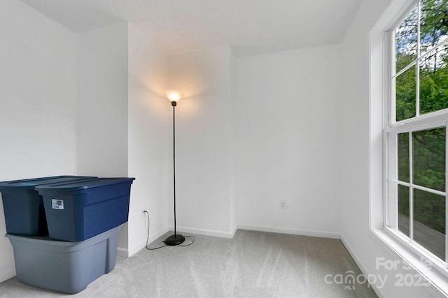empty room featuring carpet and baseboards