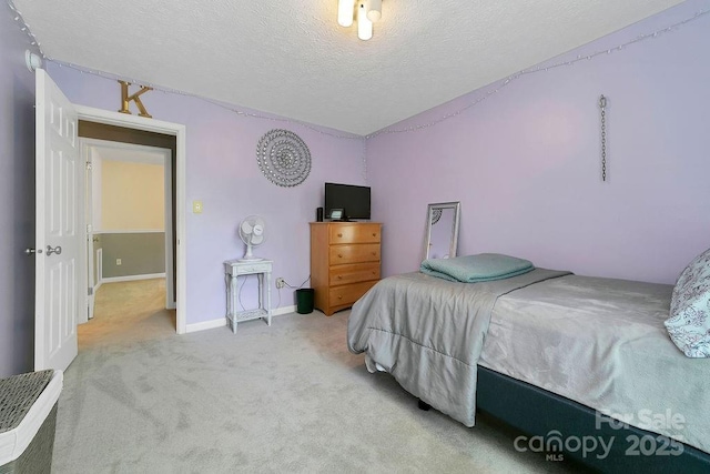 bedroom with a textured ceiling, carpet flooring, and baseboards