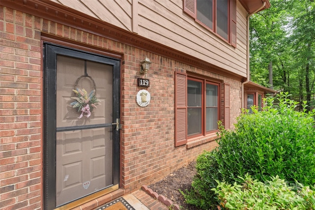 doorway to property featuring brick siding