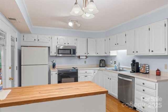 kitchen with a sink, appliances with stainless steel finishes, crown molding, and white cabinetry