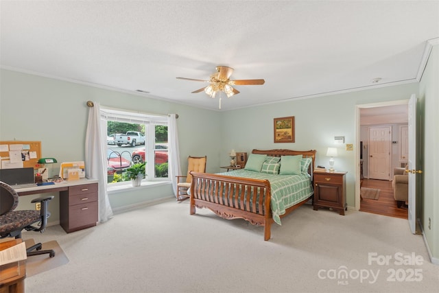 carpeted bedroom featuring baseboards, ornamental molding, a ceiling fan, and visible vents