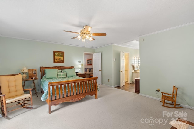 carpeted bedroom featuring baseboards, ornamental molding, a ceiling fan, and ensuite bath