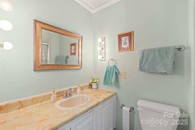 bathroom with vanity, ornamental molding, and toilet