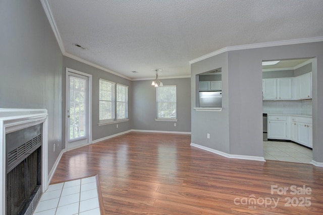 6510 Clavell Ln Unit B, Charlotte, NC 28210 - unfurnished living room featuring a fireplace with flush hearth, light wood-type flooring, visible vents, ornamental molding, and a textured ceiling