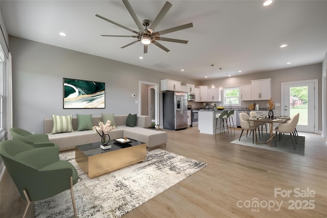 living room featuring recessed lighting, ceiling fan, light wood-type flooring, and visible vents