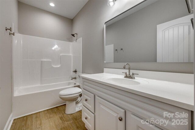 full bathroom featuring wood finished floors, vanity, toilet, washtub / shower combination, and recessed lighting