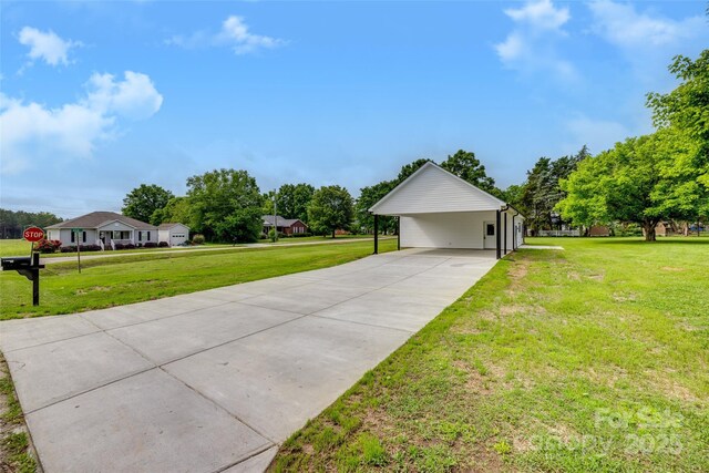 view of front facade featuring driveway, a front yard, and a carport