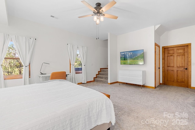 bedroom with a ceiling fan, visible vents, light colored carpet, and baseboards