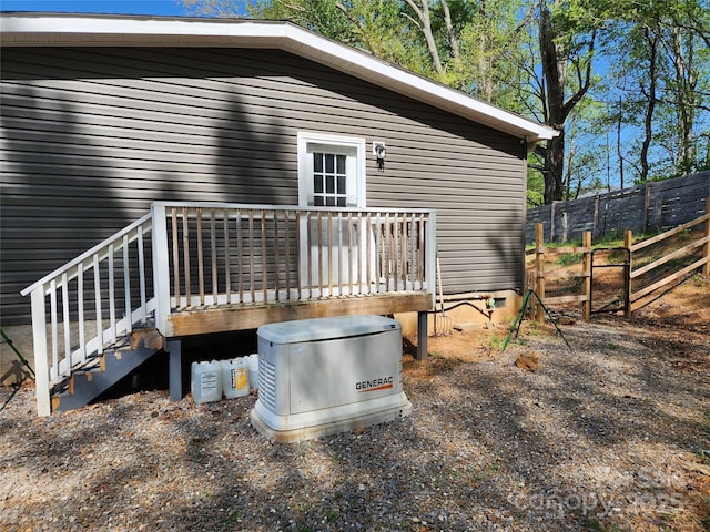 rear view of property featuring fence and a wooden deck