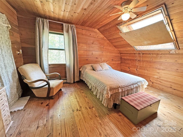 bedroom featuring vaulted ceiling with skylight, wood ceiling, wood-type flooring, and wood walls