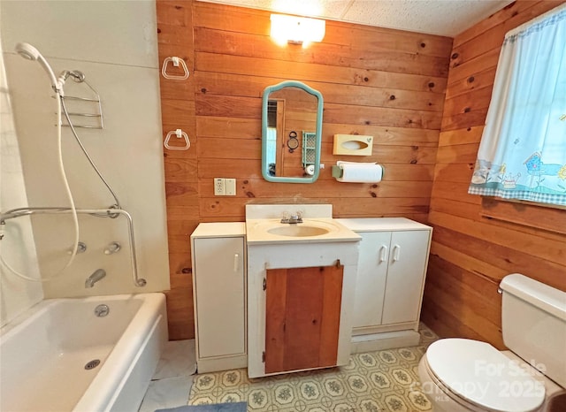 bathroom with vanity, wood walls, shower / bath combination, and toilet