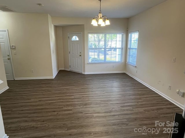 interior space featuring a chandelier, dark wood finished floors, and baseboards