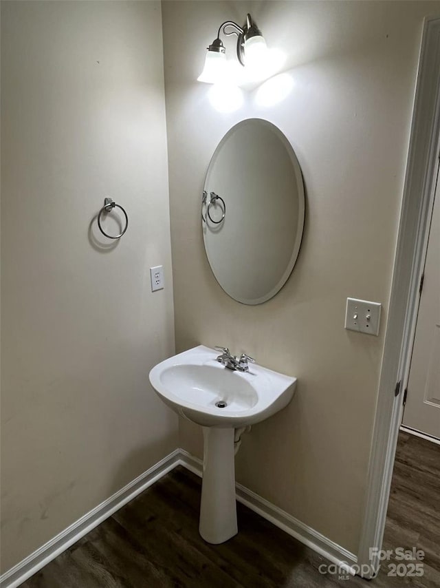 bathroom with a sink, wood finished floors, and baseboards