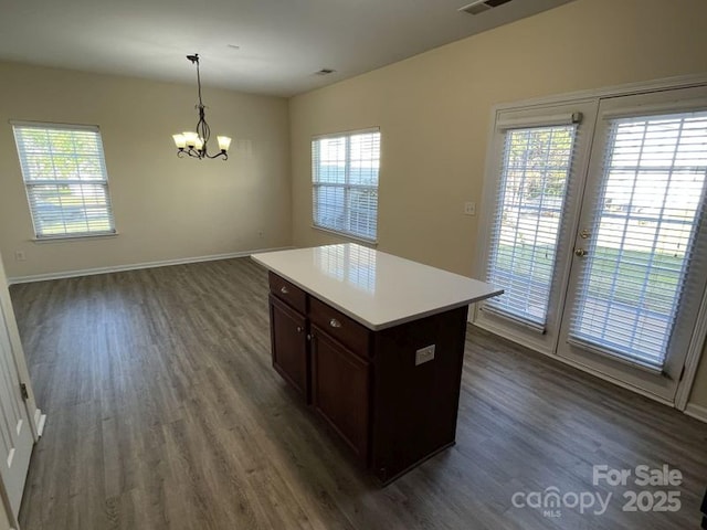 kitchen featuring dark wood finished floors, baseboards, a notable chandelier, and light countertops