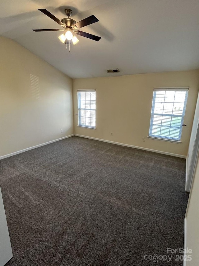 unfurnished room featuring baseboards, visible vents, and dark colored carpet