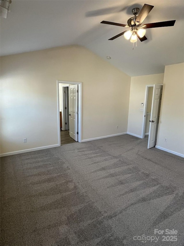 unfurnished bedroom featuring lofted ceiling, a ceiling fan, dark colored carpet, and baseboards