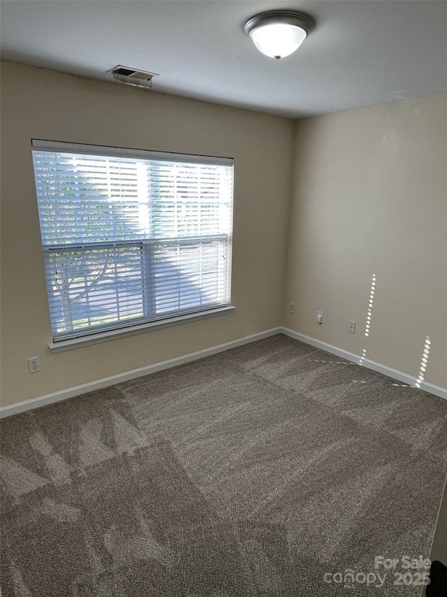 spare room featuring visible vents, carpet floors, and baseboards