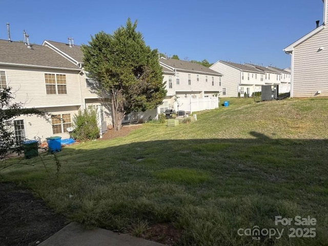 view of yard with a residential view and central air condition unit