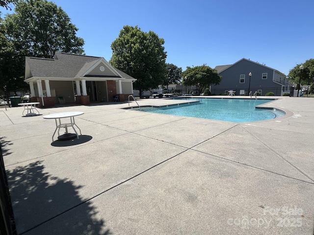 pool featuring fence and a patio area